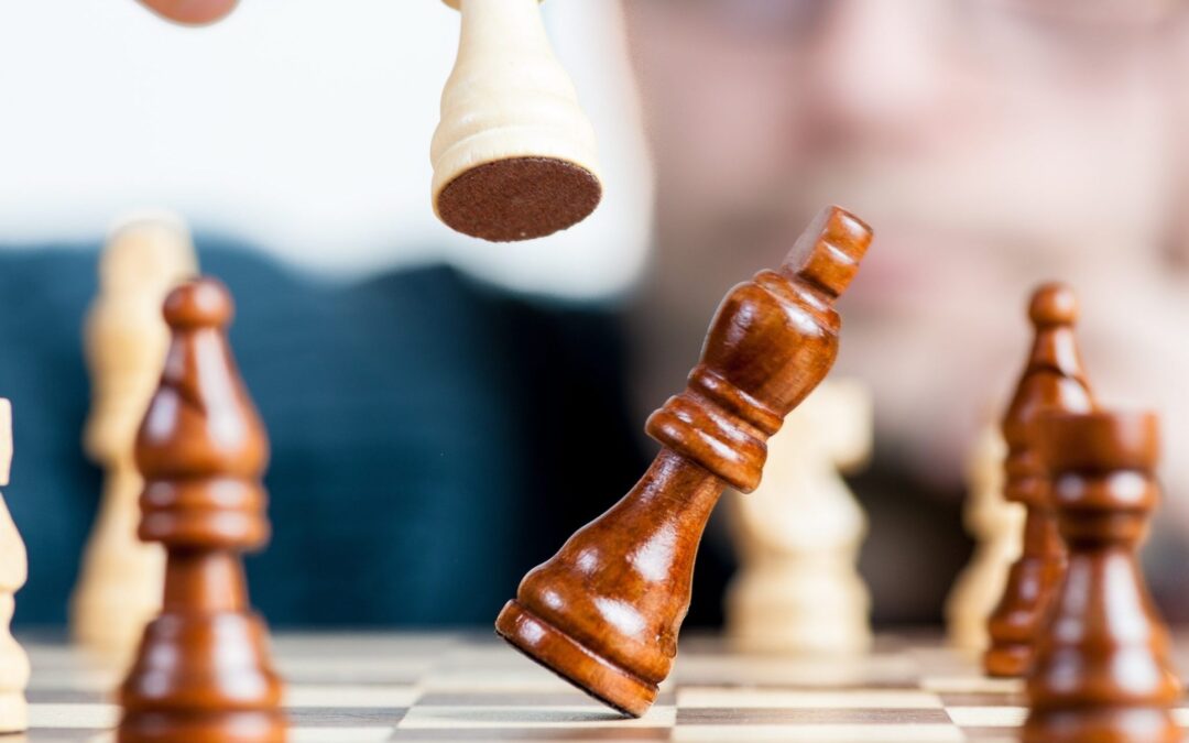 Chess pieces are being knocked over on a chess board to illustrate the need for a cash flow strategy in business.