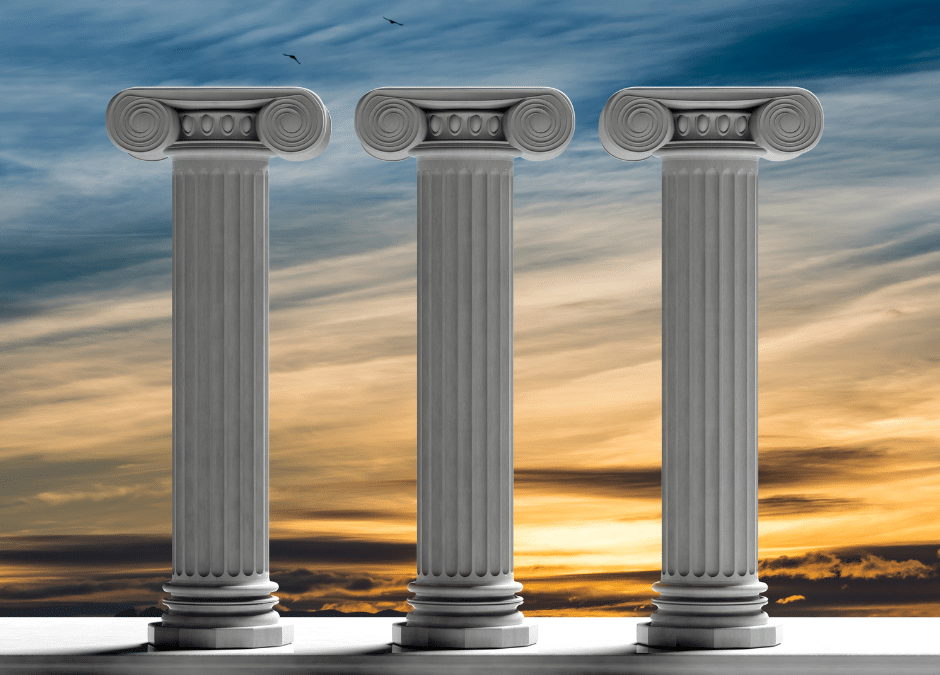 3 classical pillars against a sunrise.