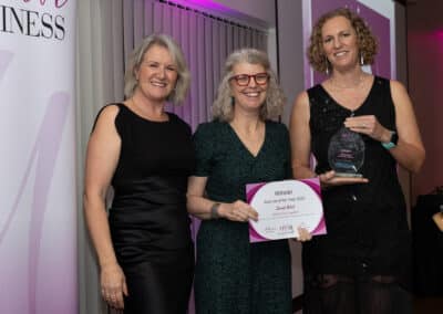 Louise Jenner, Sarah West and Lee McQueen pictured at the DWIB Awards 2025. Sarah is in the centre, holding her certificate as Lee presents her with her trophy for Start Up of the Year.