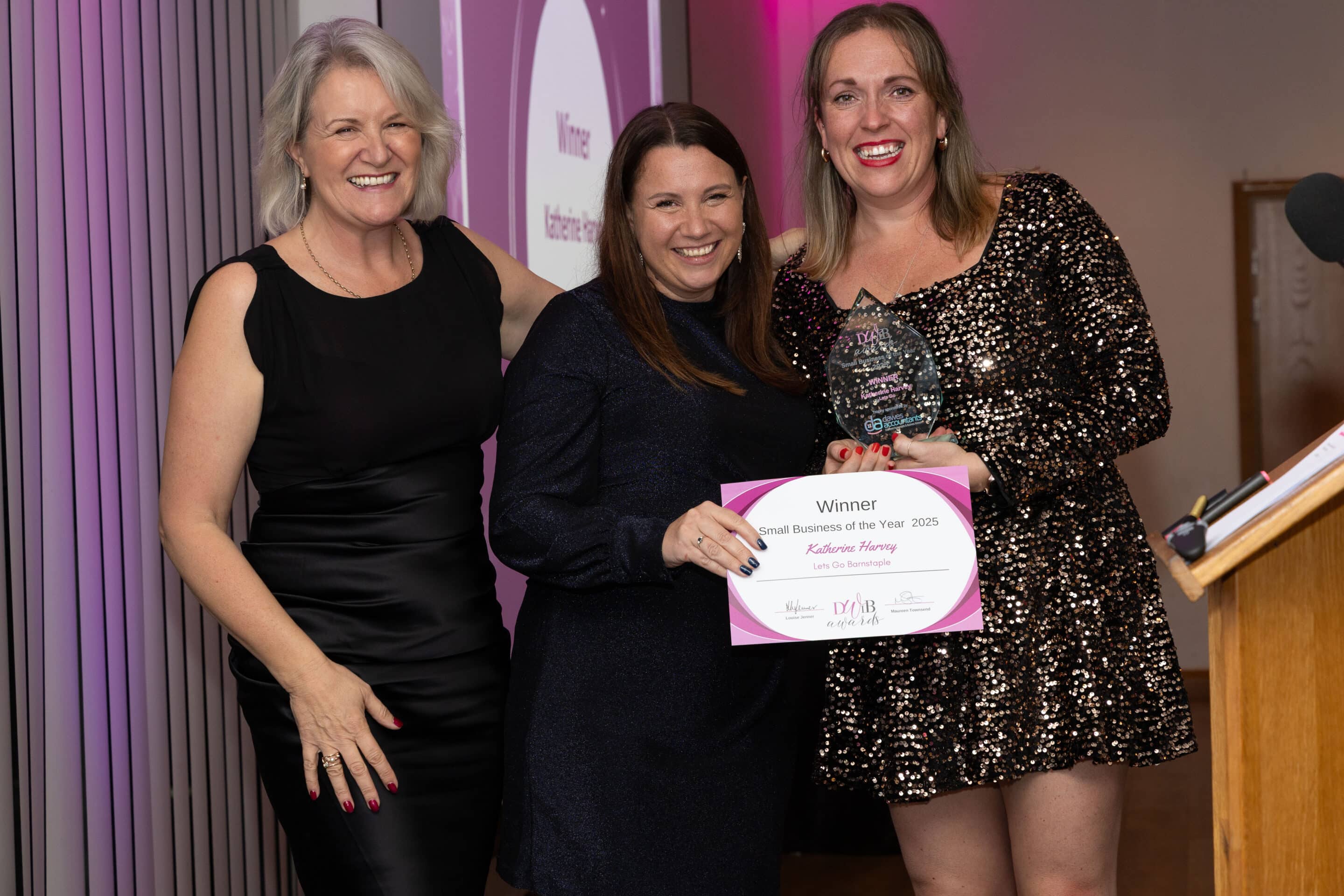 Louise Jenner and Emma Woodward present Katherine Harvey with her DWIB Award for Small Business of the Year 2025.
