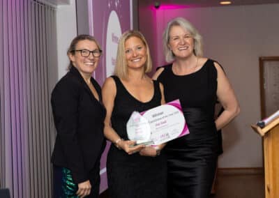 Davina Cull and Louise Jenner present Kate Smith (centre) with her DWIB Award for Charity of the Year 2025.