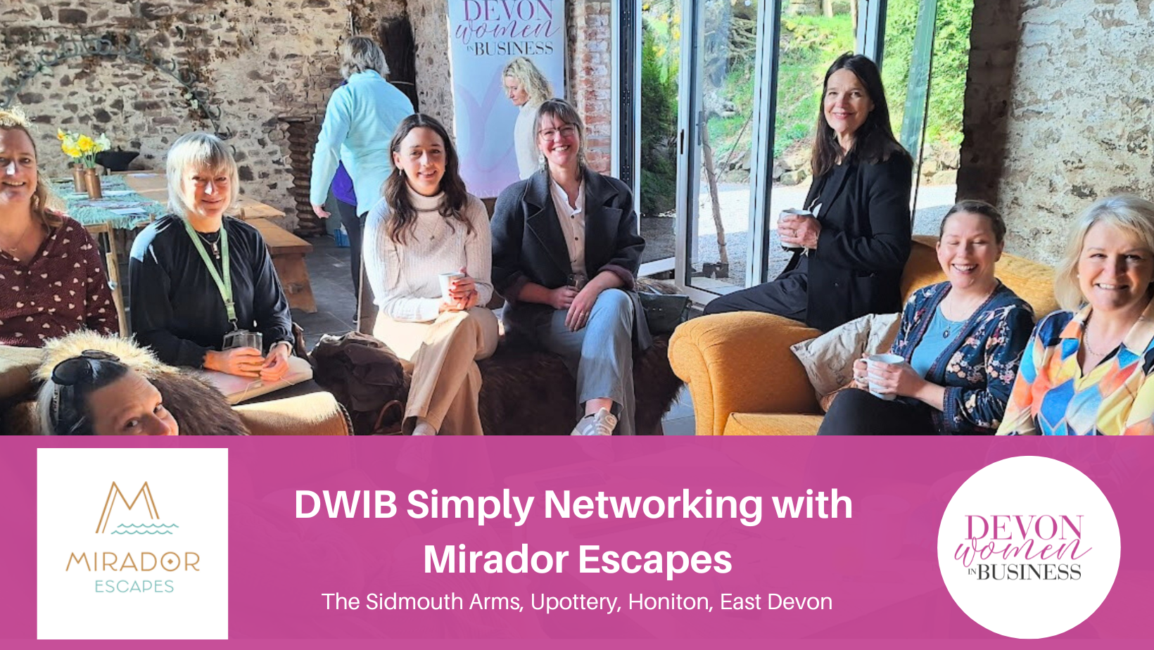 A group of DWIB members sitting together on sofas and chairs, enjoying a relaxed networking session with cups of tea and coffee. They’re smiling and chatting in a rustic venue with stone walls and large windows. Below the photo is a pink banner with the Mirador Escapes logo, the event title “DWIB Simply Networking with Mirador Escapes,” and the Devon Women in Business logo.