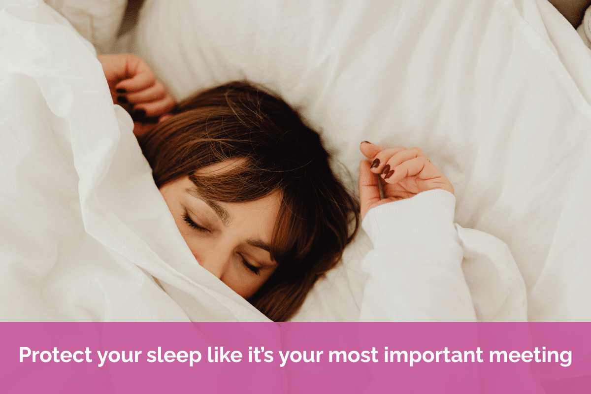 Person sleeping peacefully in a comfortable bed with white bedding, representing the importance of quality sleep for wellbeing, productivity, and working from home successfully.