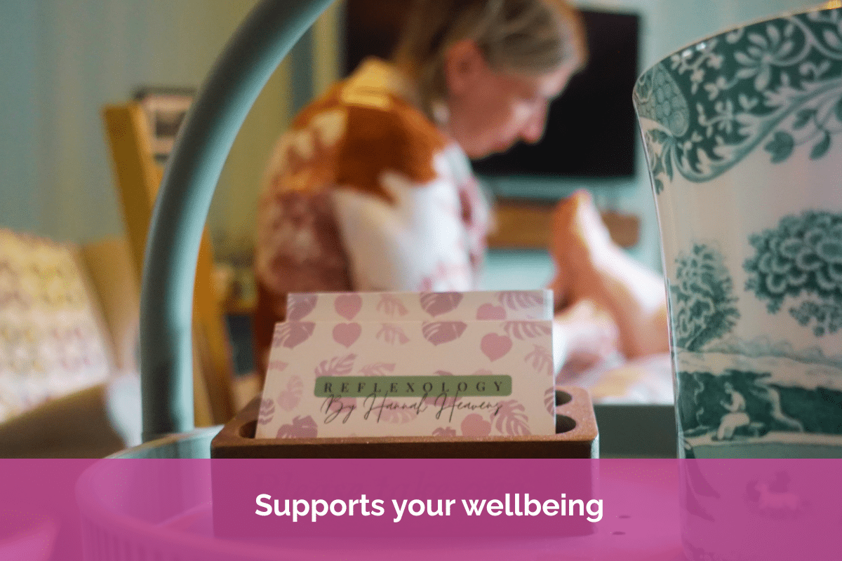Business card for Reflexology by Hannah Heavens in the foreground, with a reflexology treatment taking place in the background, promoting relaxation and wellbeing.