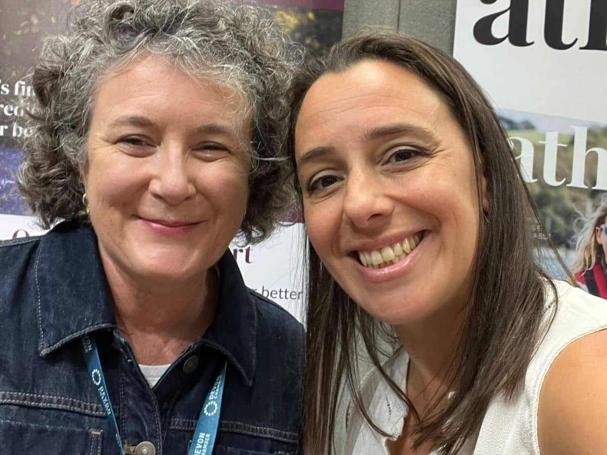 Devon Women in Business members Kirsty Hale and Fran Minifie smiling together at the Devon Business Show 2026, with Kirsty Hale Nutrition and Athena Magazine banners behind them.